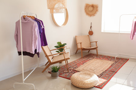 Interior of light dressing room with clothes and armchairsの写真素材