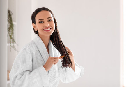 Young woman brushing her hair in bathroomの写真素材