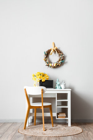 Interior of room with workplace and Easter decor near light wallの写真素材