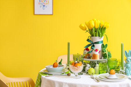 Stylish dinnerware on table served for Easter celebration near color wallの写真素材