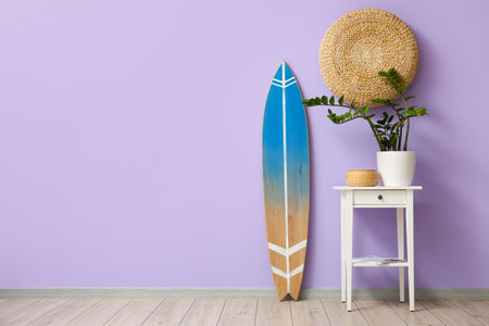 Interior of room with surfboard and table near color wall