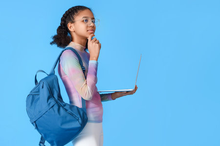 African-American female student with laptop on blue background