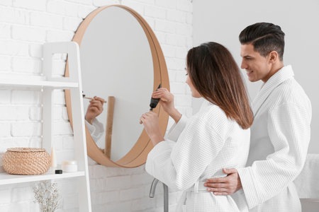 Young couple brushing teeth with activated charcoal tooth paste in bathroomの写真素材