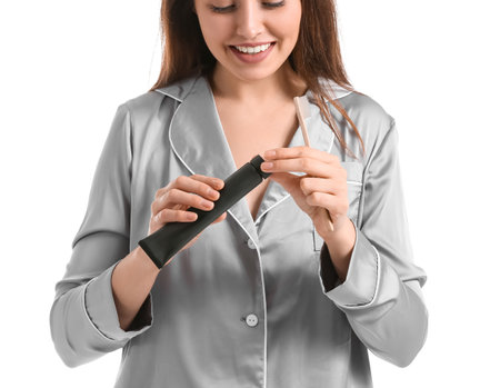 Beautiful young woman with activated charcoal tooth paste and brush on white backgroundの写真素材