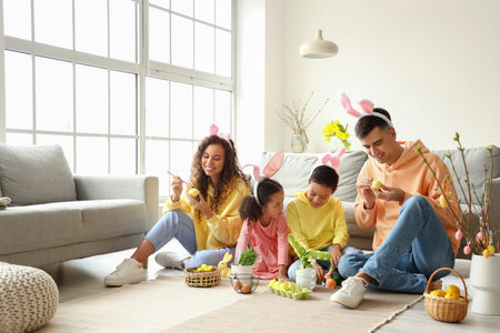 Little children with their parents painting Easter eggs at home