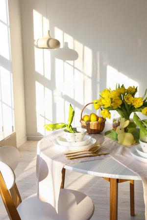 Beautiful table setting for Easter celebration on table in light roomの写真素材