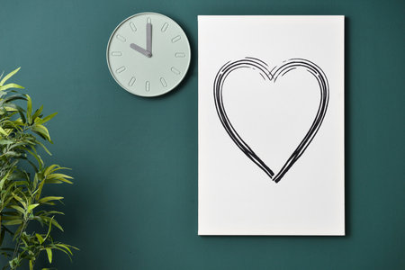 modern clock and picture hanging on color wall in roomの写真素材