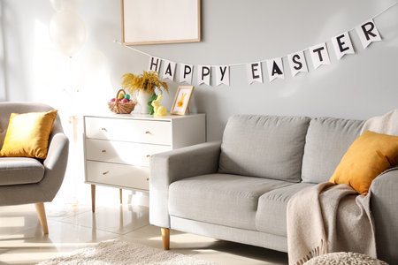 Chest of drawers with basket of Easter eggs and decor near light wall in living room interiorの写真素材