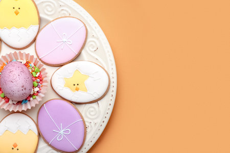 Plate with tasty Easter cookies and egg on color background