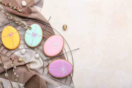 Grid with tasty Easter cookies, eggs and pussy willow branches on light backgroundの写真素材