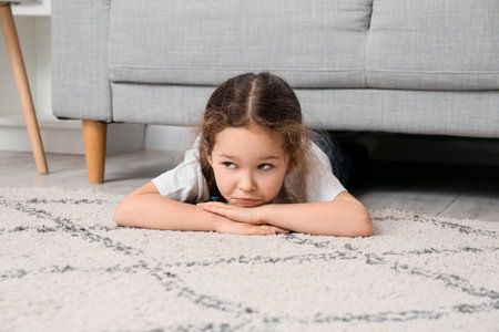 little girl lying on carpet at homeの写真素材
