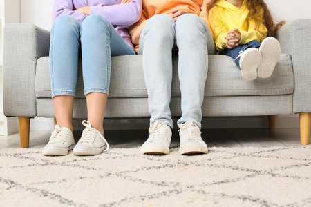 Young family sitting on couch at home