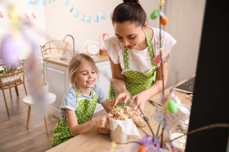 Little girl with her mother preparing Easter cake in the kitchen