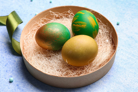Plate with painted Easter eggs on color backgroundの写真素材