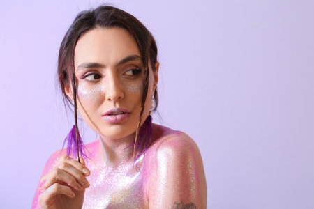 Beautiful young woman with glitters on her face and body against color background