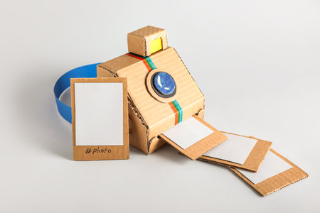 Cardboard photo camera with pictures on light backgroundの写真素材