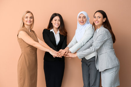 Beautiful women putting hands together on color background. unity conceptの写真素材