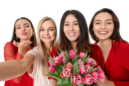 Beautiful women with flowers taking selfie on white background. International Women's Day celebrationの写真素材