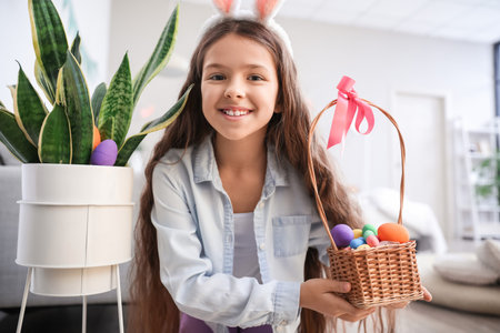 Cute little girl looking for Easter eggs at homeの写真素材