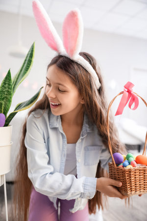 Cute little girl looking for Easter eggs at homeの写真素材