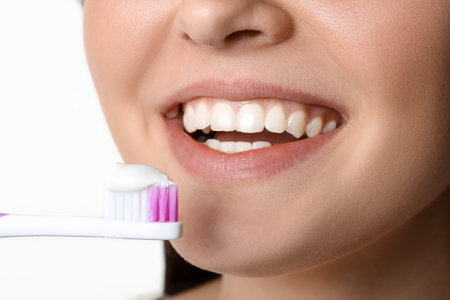 Young woman and toothbrush with paste on white background, closeupの写真素材