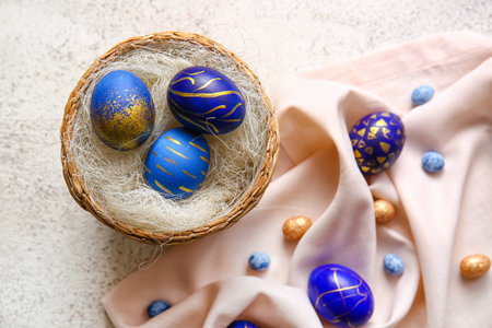Basket with stylish Easter eggs on light backgroundの写真素材