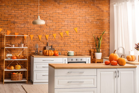 Interior of modern kitchen with Halloween pumpkins, counters and shelving unitの写真素材