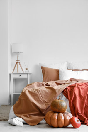 Interior of cozy bedroom with pumpkins and lampの写真素材