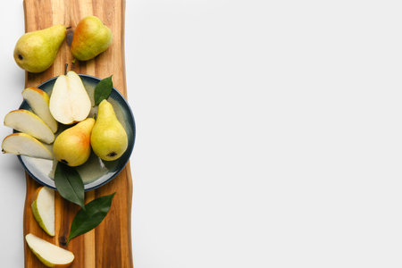 Plate with ripe pears on wooden board isolated on white backgroundの写真素材