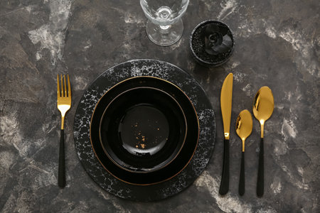 Stylish table setting with golden cutlery on grunge backgroundの写真素材
