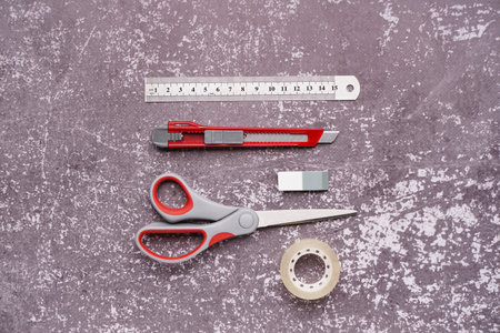 Utility knife with stationery on grunge background
