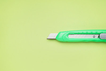 Utility knife on green background, closeupの写真素材