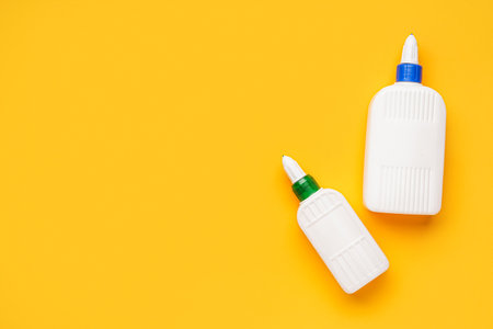 bottles of glue on orange background