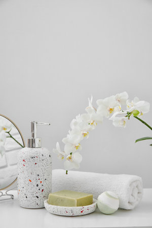 Set of bath supplies with orchid flower on light backgroundの写真素材