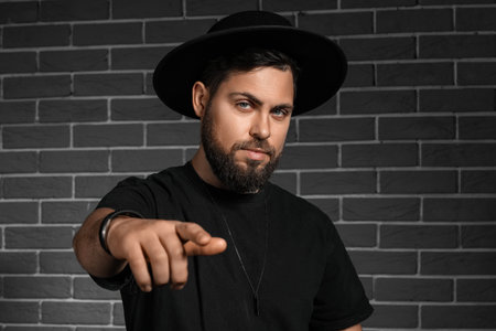 Stylish bearded man on dark brick background