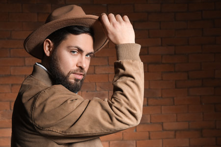 Stylish bearded man against brick wallの写真素材
