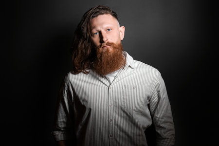 Portrait of handsome bearded man on dark background