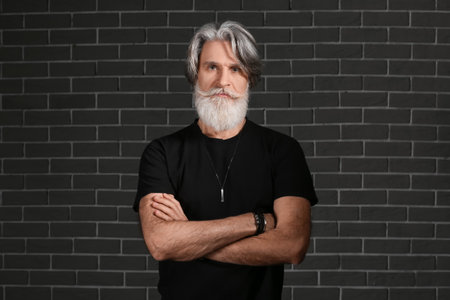 Portrait of handsome mature bearded man on dark backgroundの写真素材