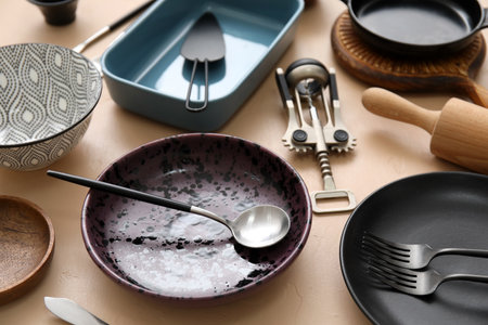 Many different tableware and kitchenware on color background
