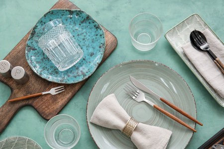 Many different tableware on green background