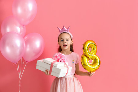 Little girl with gift and balloons on pink background. International Women's Day celebration