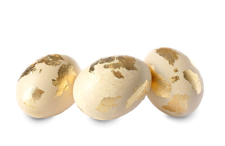 Easter eggs decorated with gold foil on white background