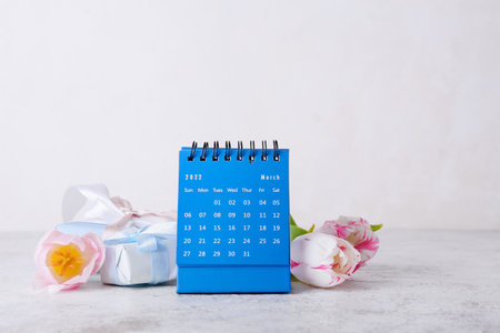 Calendar, gift box and flowers for International Women's Day celebration on light backgroundの写真素材
