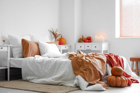 Interior of cozy bedroom with pumpkins and burning candlesの写真素材