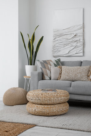 Interior of modern living room with gray sofa, poufs and 3D textile artworkの写真素材