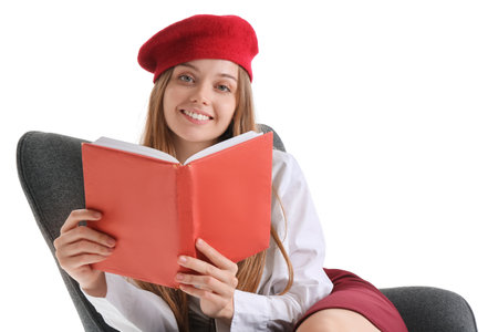 Stylish young woman with book sitting in armchair on white backgroundの写真素材