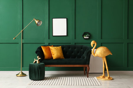 Interior of room with golden flamingo, sofa and blank photo frame near green wallの写真素材