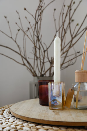 Candle in holder and reed diffuser on tableの写真素材