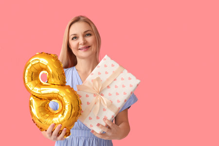 Woman with gift box and balloon in shape of figure 8 on color background. International Women's Day...