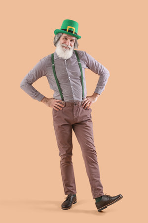 Senior man in green hat on beige background. St. Patrick's Day celebrationの写真素材